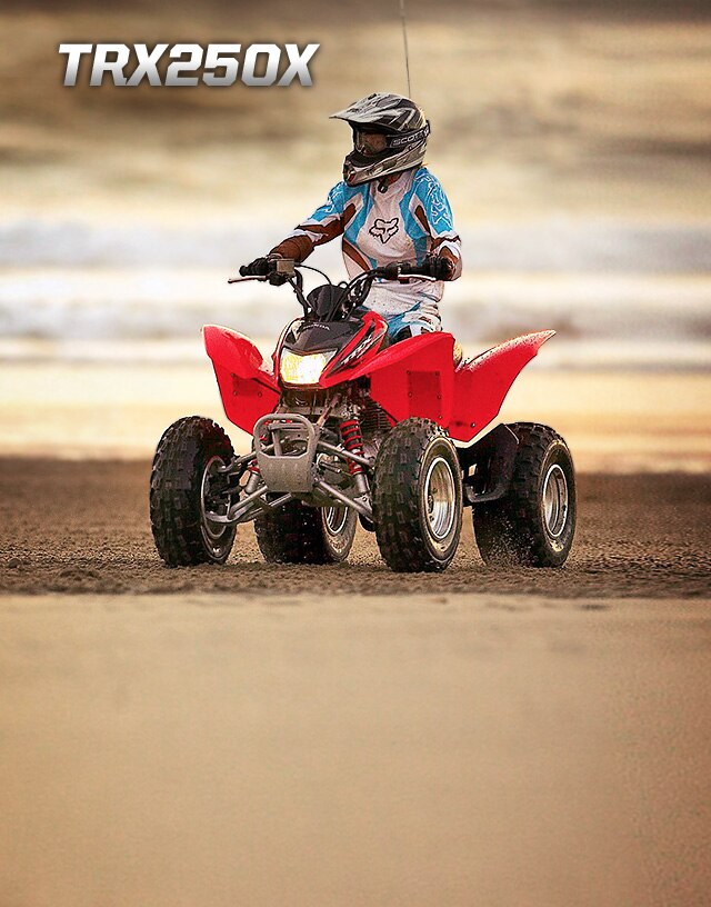 TRX250X. Adrenaline uninterrupted. Image of determined rider wearing ATV sport suit speeding up a dusty, dirt incline on red ATV.