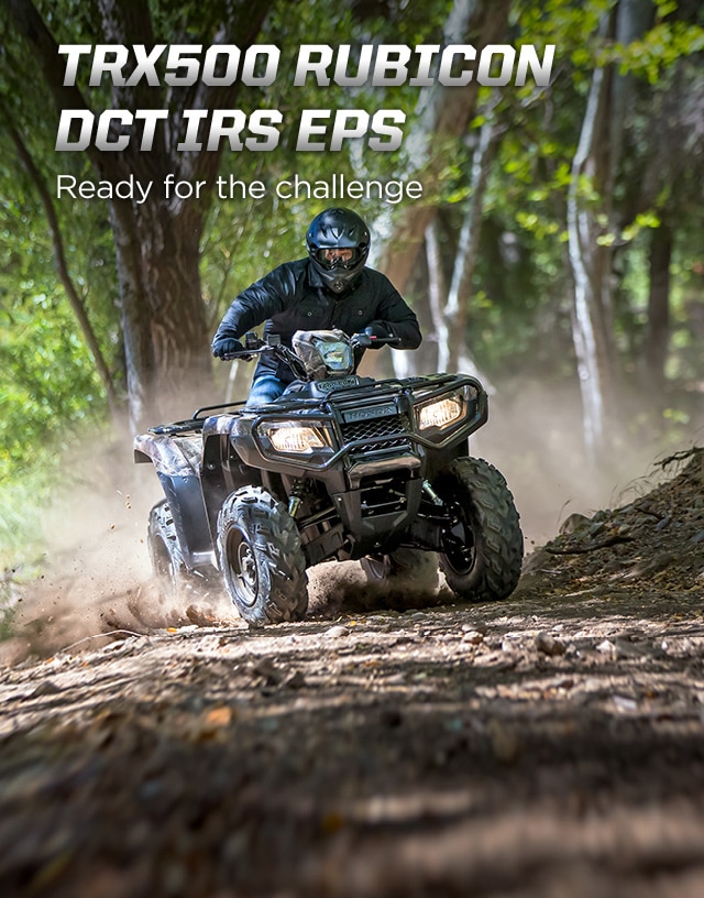 TRX500 Rubicon DCT IRS EPS. Ready for the challenge. Image of ATV rider powerfully steering up rugged dirt trail in the forest