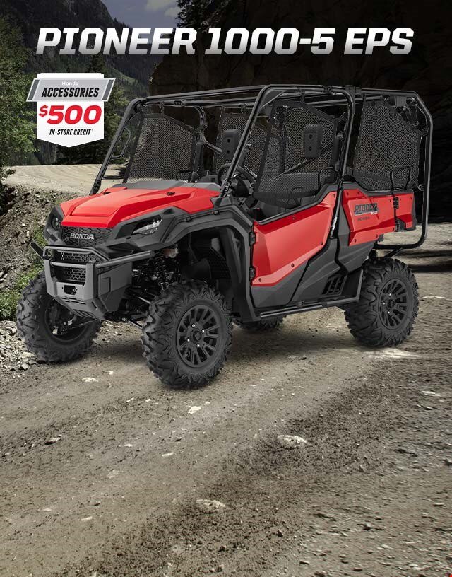 Pioneer 1000-5 EPS. Go beyond extraordinary. Image of a striking red side-by-side parked on wild off-road terrain among blue skies and snow capped mountain peaks