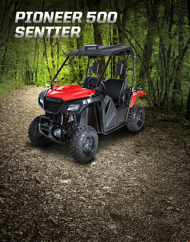 Pioneer 500 avec ensemble Sentiers Partout c'est l'aventure. Côte à côte avec toit rigide et barre d'éclairage prêt à explorer une piste qui s'enfonce dans la forêt profonde.