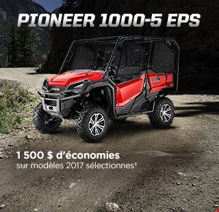 Pioneer 1000-5 EPS. Au-delà de l'extraordinaire. Image d'un superbe VCC rouge stationné sur un terrain accidenté en pleine nature avec ciel bleu et pics enneigés