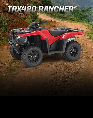 TRX420 Rancher. Modest size, bold personality. Image of rider on ATV manouevering over large rocks on a rugged trail incline.