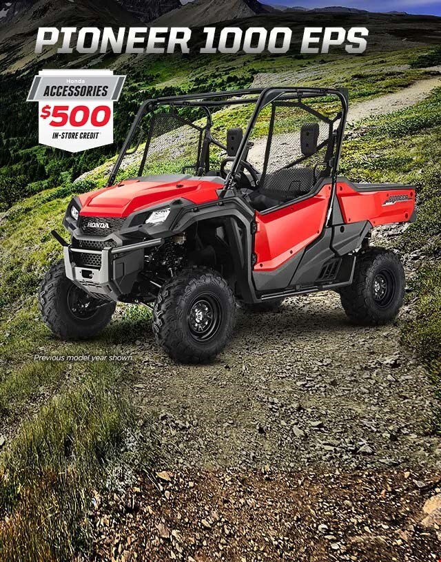 Pioneer 1000 EPS. Go beyond extraordinary. Image of a striking red side-by-side parked on wild off-road terrain among blue skies and snow capped mountain peaks